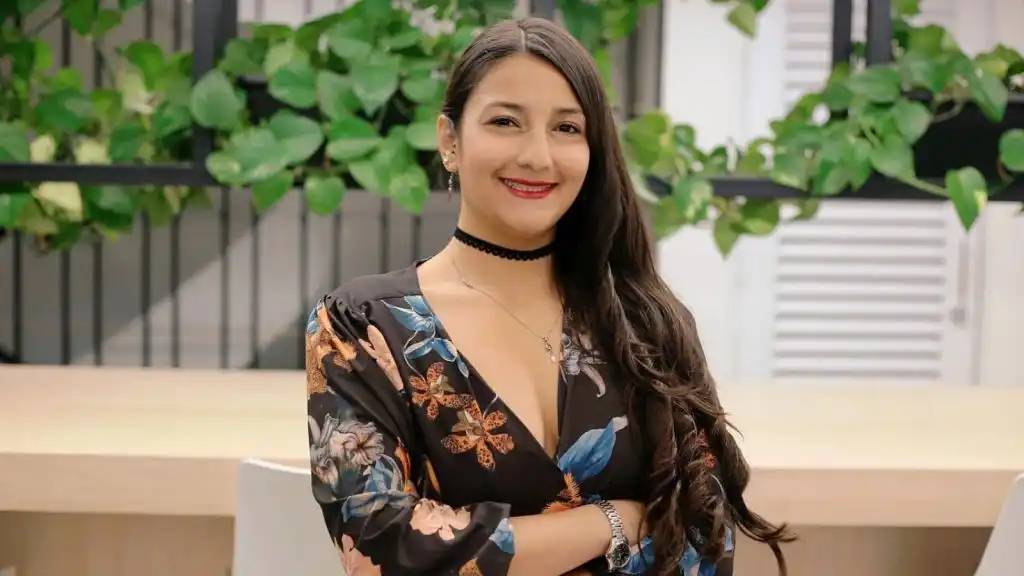 Foto Paula Andrea Escallón Castiblanco, egresada de la Universidad del Rosario sonriendo con los brazos cruzados.