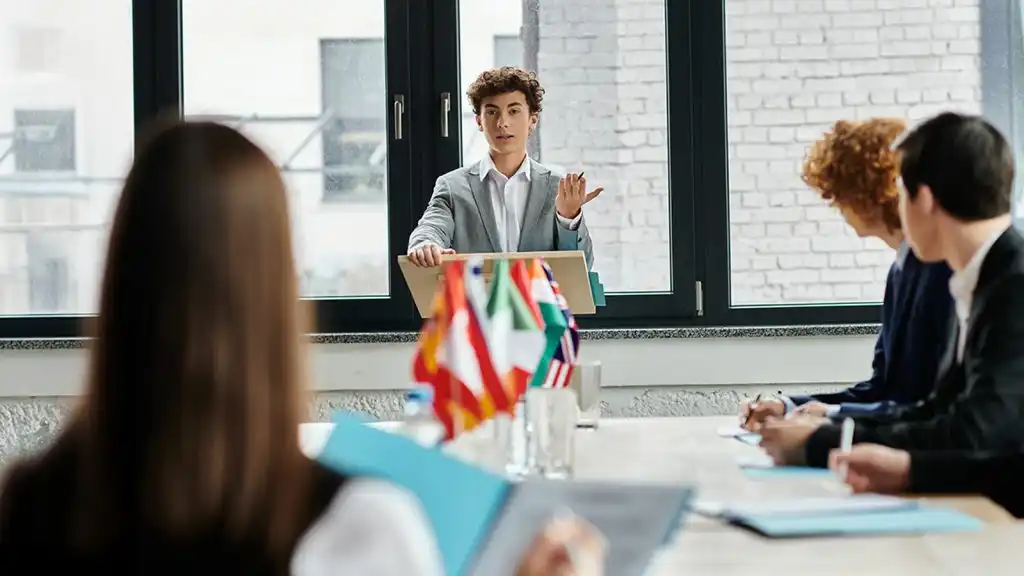 Grupo de jóvenes estudiantes participando en un modelo de Naciones Unidas, debatiendo temas políticos y sociales que ejemplifican la diferencia entre ciencias sociales y ciencias políticas.